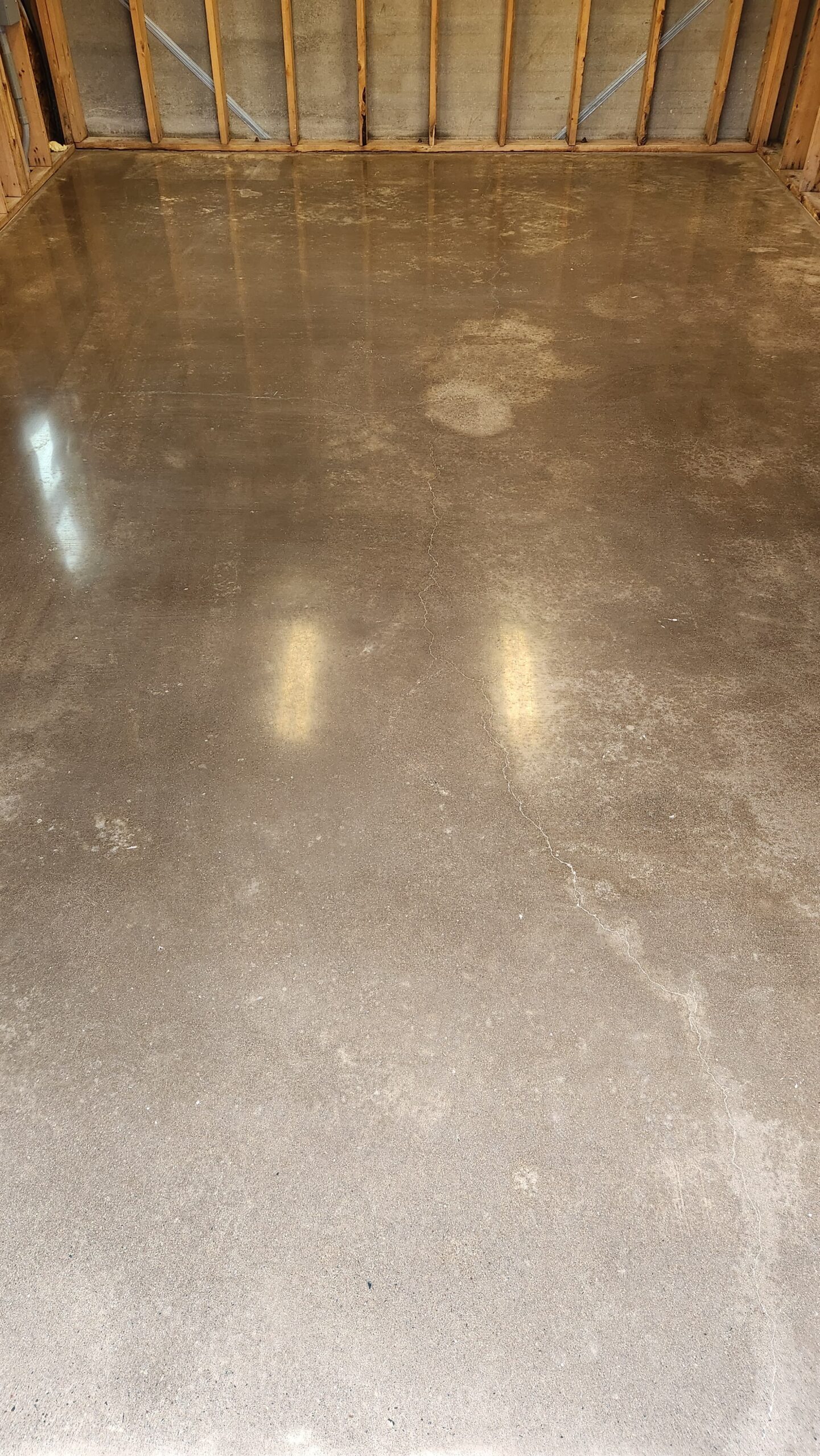 Clear protective concrete sealer applied to a newly ground garage floor for a clean, dust-free finish.