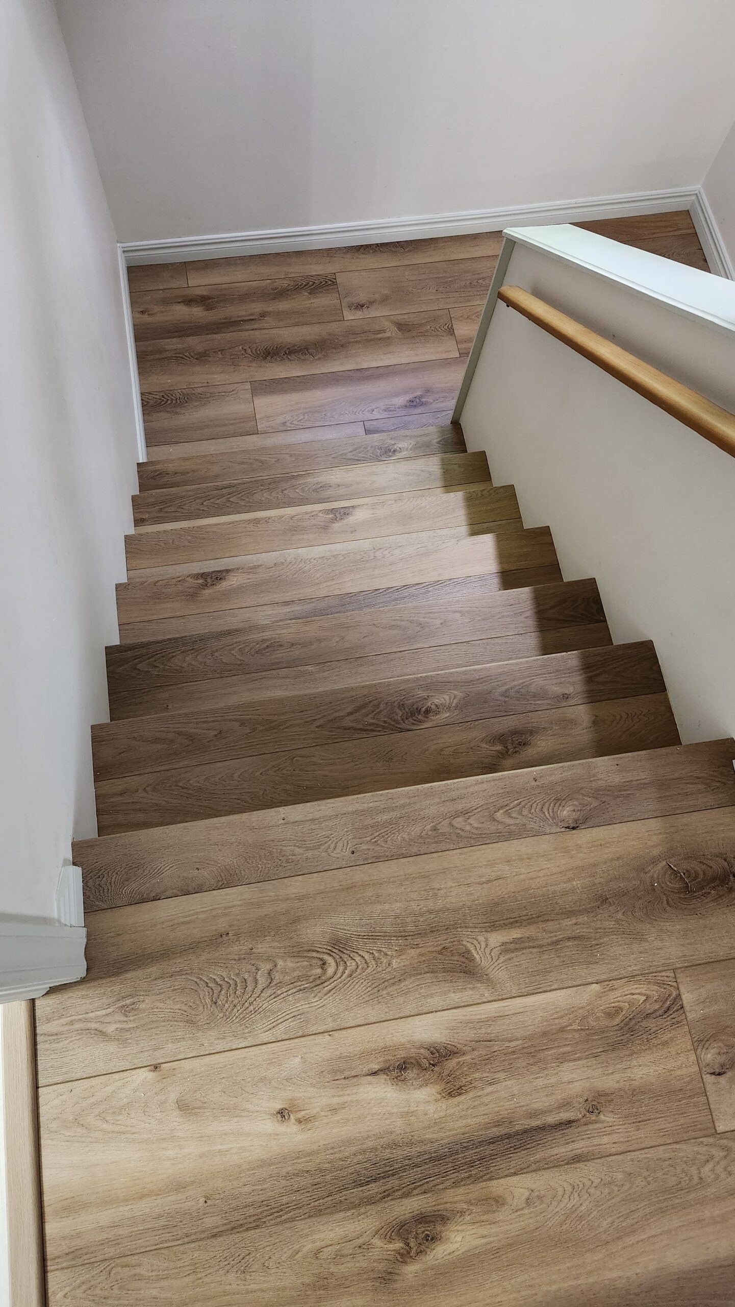 Professional luxury vinyl plank installation on a staircase in Halifax, featuring perfectly mitered matching nosing.