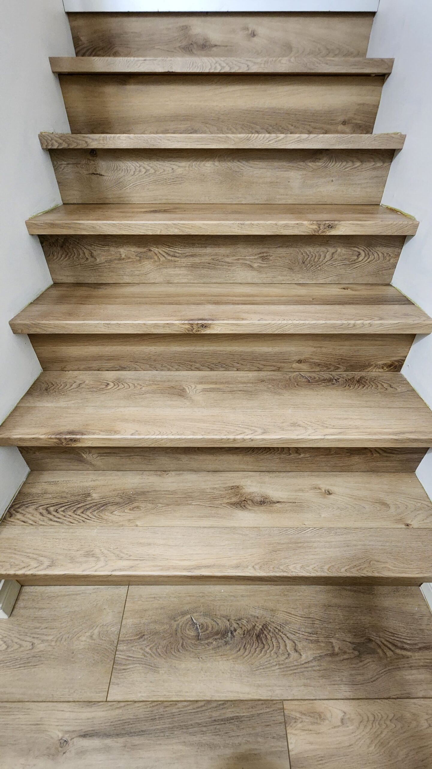 Expertly installed luxury vinyl plank on a staircase with matching nosing for a clean finish.