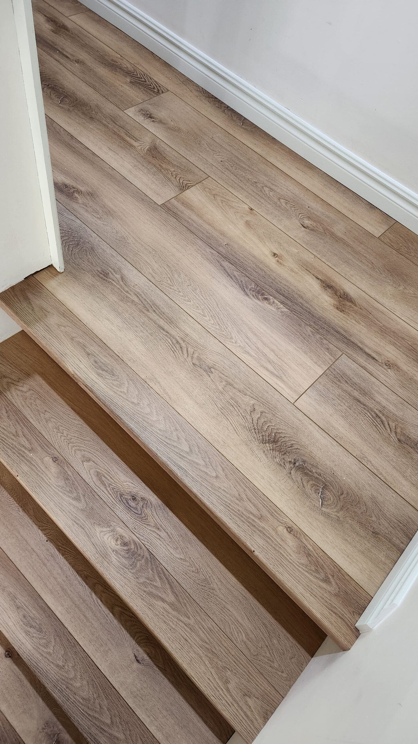 Durable and waterproof LVP flooring applied to stairs, a perfect solution for high-traffic entryways in HRM homes.